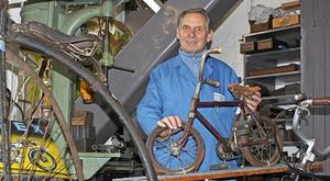 Peter Schulz mit historischen Rädern in seiner ehemaligen Werkstatt. Foto: slu (Bild: 1/2)
